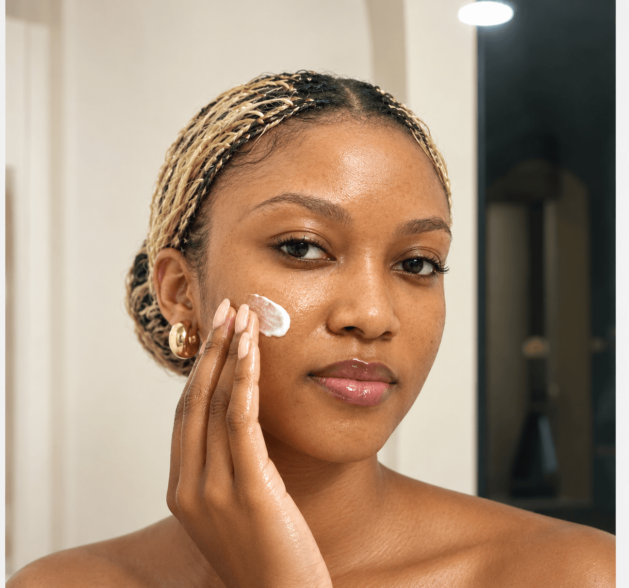 Woman applying moisturizer to her cheek